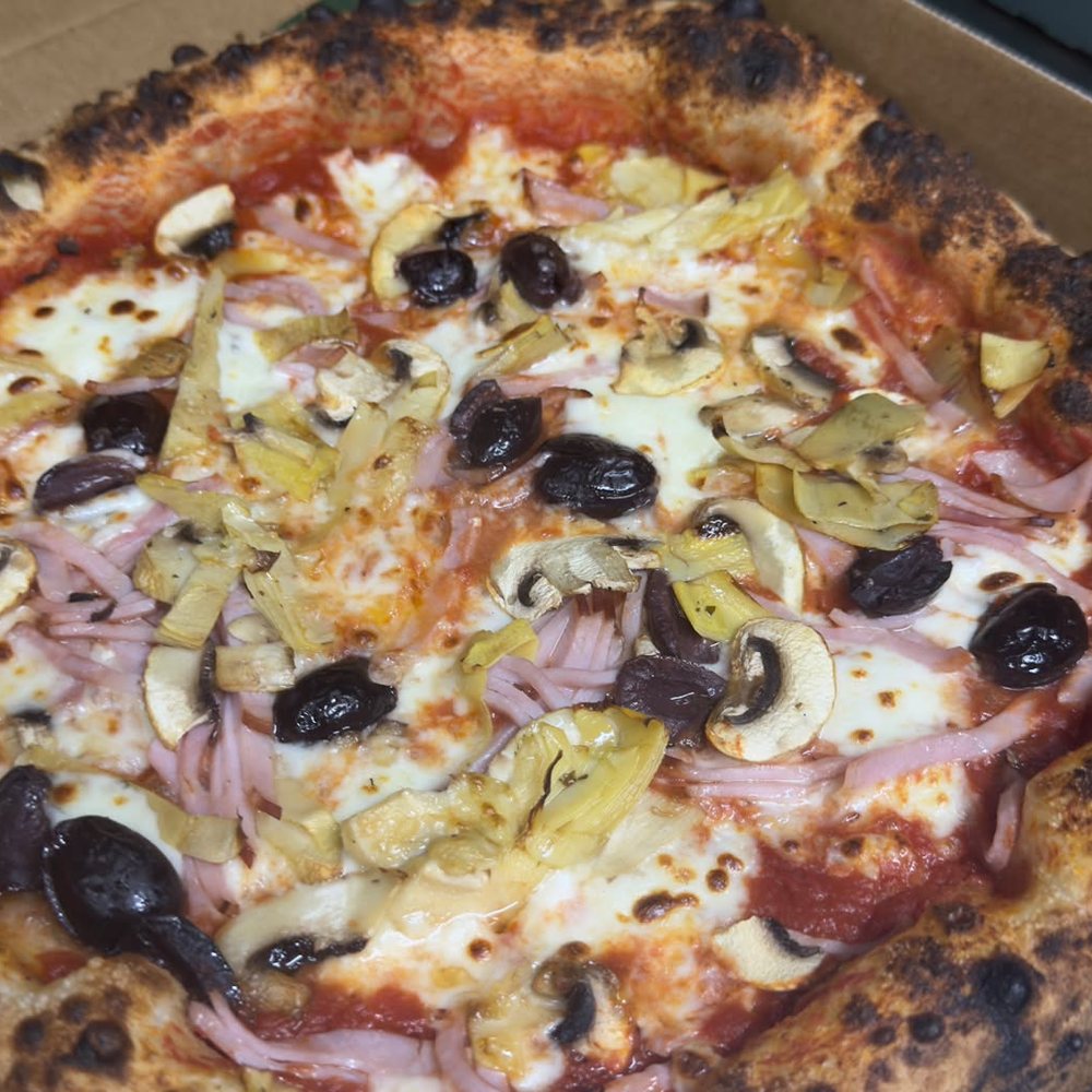 Pizza with ham, mushrooms, artichokes and olives