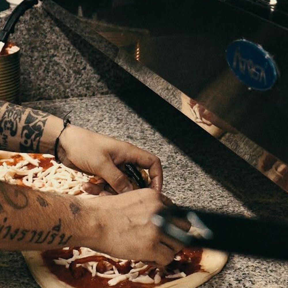 Topping a pizza base by hand in the truck